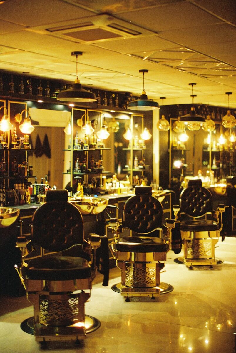 Luxurious barber chairs and sinks in a dimly lit salon